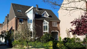 A residential house with a sloped roof, a front porch, and a brick facade.