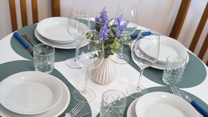 A table set with white plates, clear glasses, and a vase with purple flowers. - Lòbia in via Parrochiale - app. Legno (P2) (Barzio)