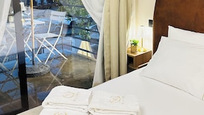 A hotel room with a bed, a nightstand, and a window with curtains. - Villa Garden Boutique Hotel Tirana (Tirana)