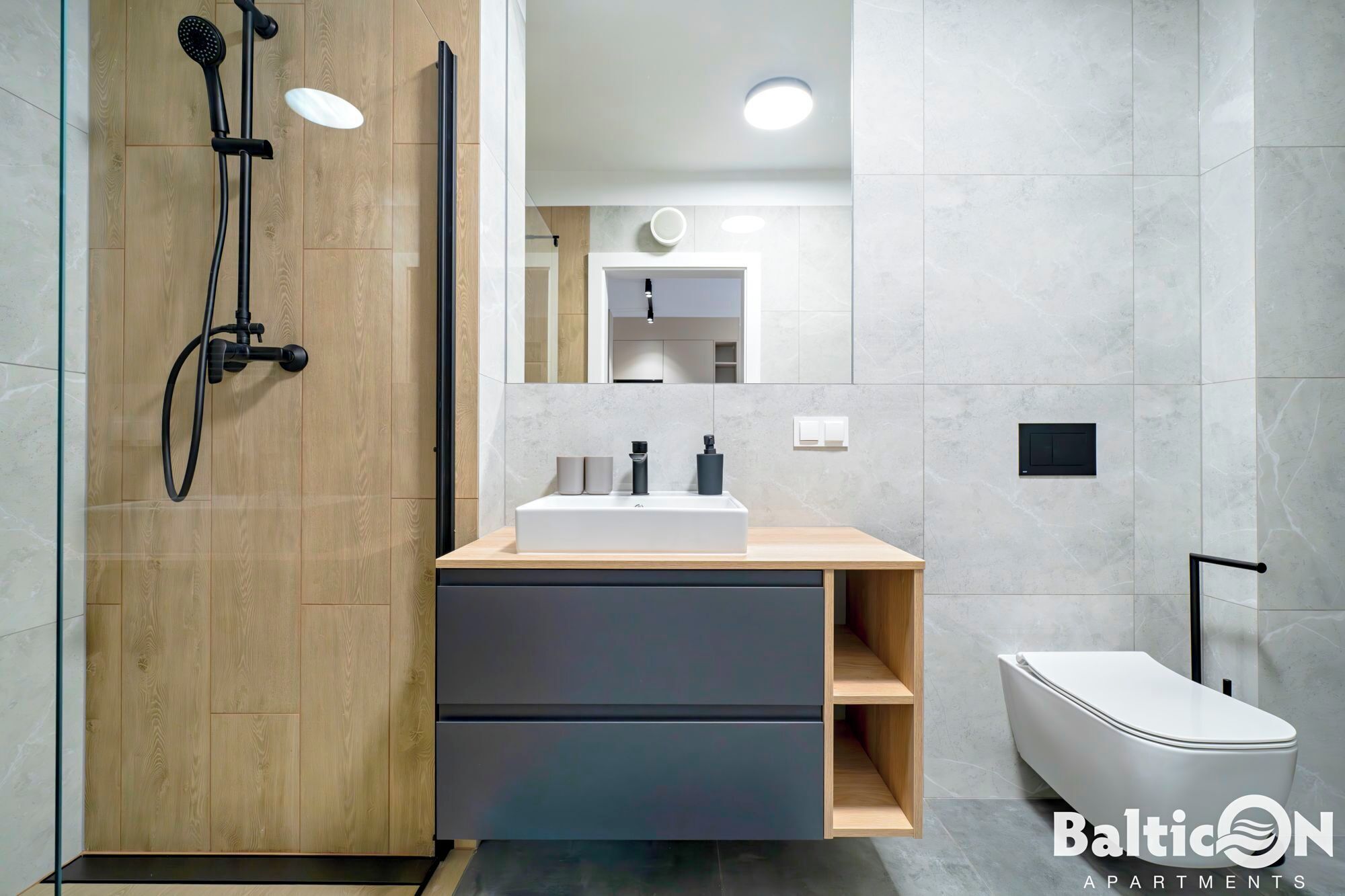 A modern bathroom with a wooden vanity, a white sink, and a shower with a handheld showerhead.
