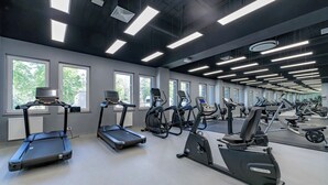 A gym with multiple treadmills, stationary bikes, and elliptical machines. - BalticON Apartments Kasprowicza (Kolobrzeg)