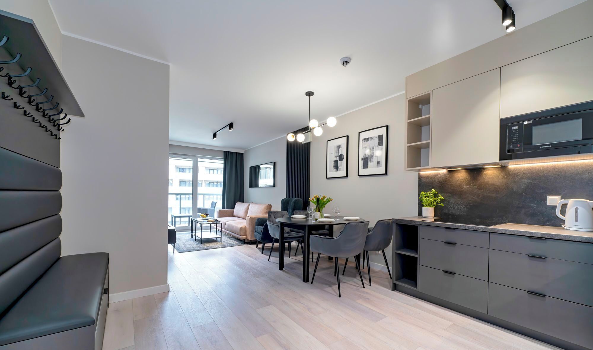 A modern apartment with a dining area, kitchen, and living space.