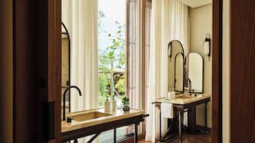A bathroom with a sink, mirror, and window.