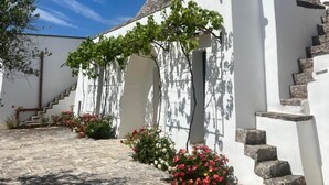 Un bâtiment blanc avec des toits en pierre et un escalier menant à l’entrée.