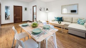 Uma sala de estar moderna com sofá, mesa de jantar e luminária.