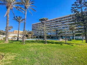 A hotel with a large building, a swimming pool, and palm trees. - Balcony overlooking the sea - Sea view (Torremolinos)