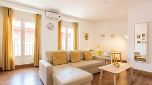 Una sala de estar moderna con un sofá, una mesa de centro y un comedor con sillas y una mesa.