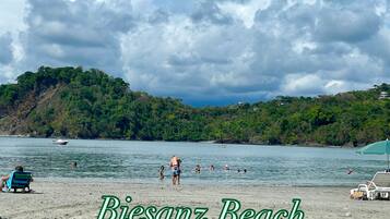A beach scene with a sign stating "Biesanz Beach 30 minutes from Paraiso".