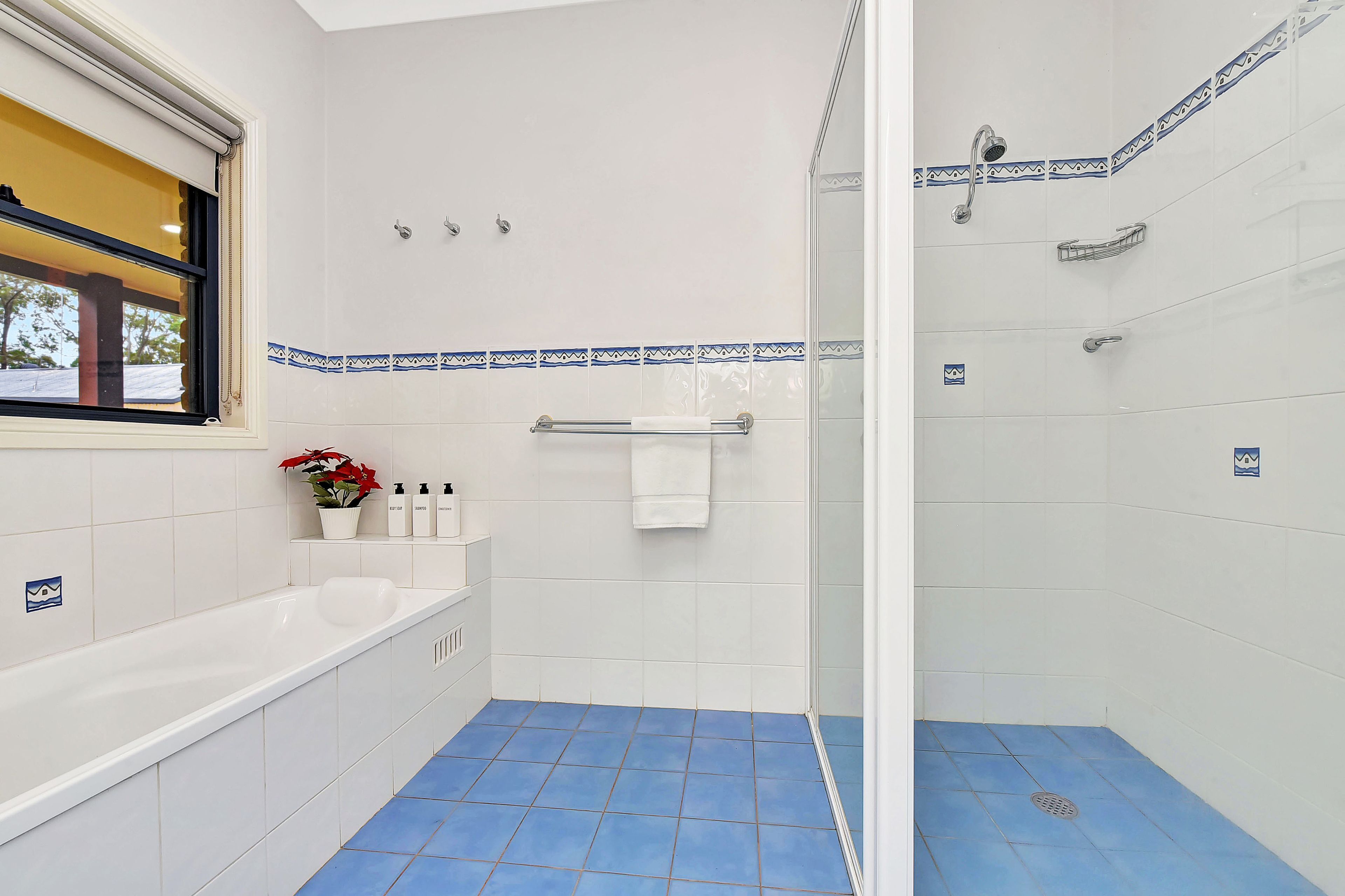 Un baño con bañera, ducha y ventana.