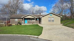 A two-story house with a brick exterior and a blue door.