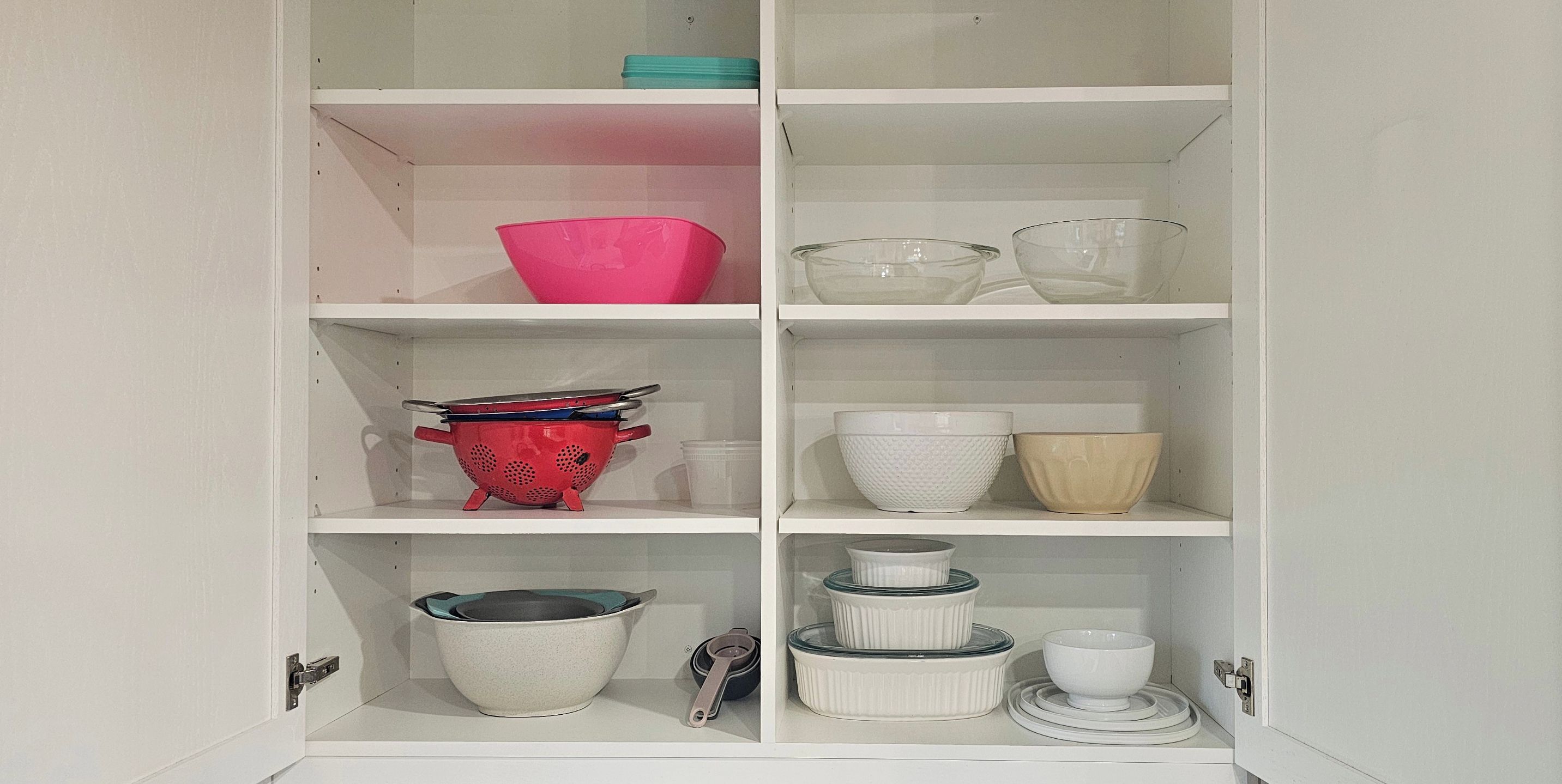 Un armario de cocina con repisas que contienen diferentes utensilios de cocina.