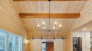A spacious conference room with a long wooden table, black chairs, and a modern chandelier. - Faloma Lakeside Cabins (Faloma)