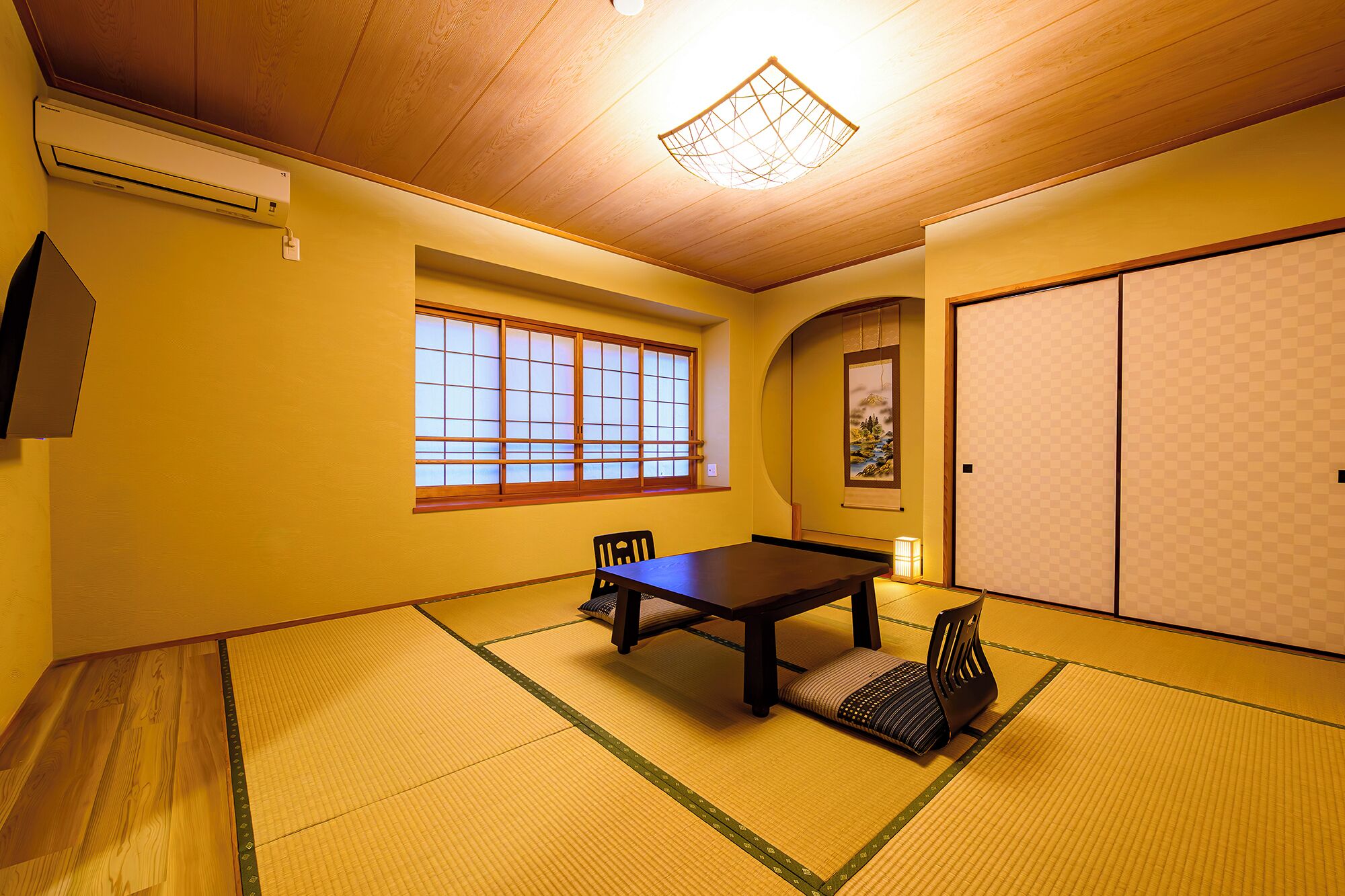 A traditional Japanese room with tatami flooring, a sliding door, and a window with wooden frames.