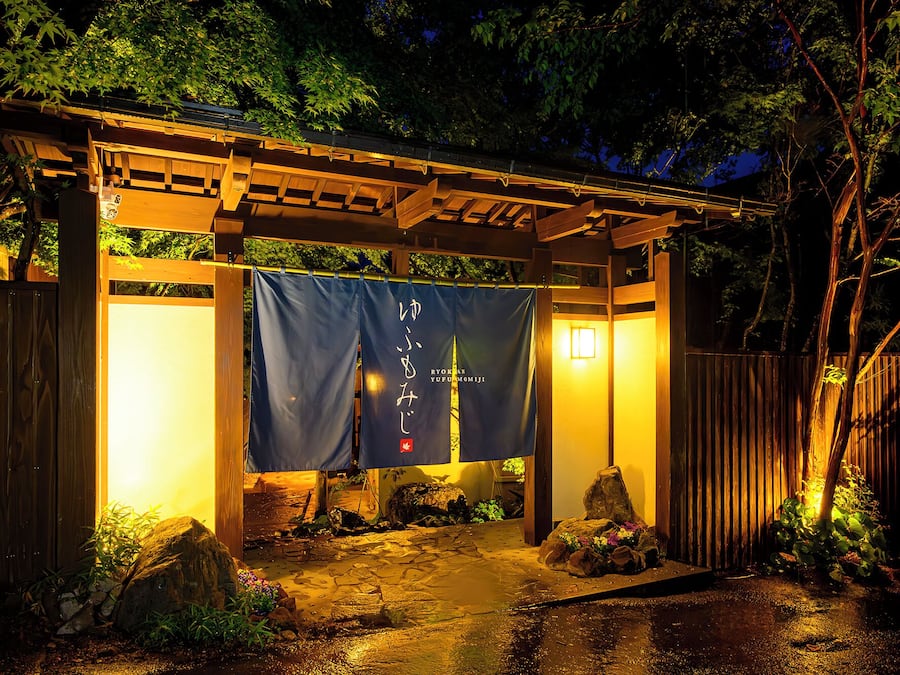Estructura japonesa tradicional con techo de madera y un estandarte con caracteres japoneses.