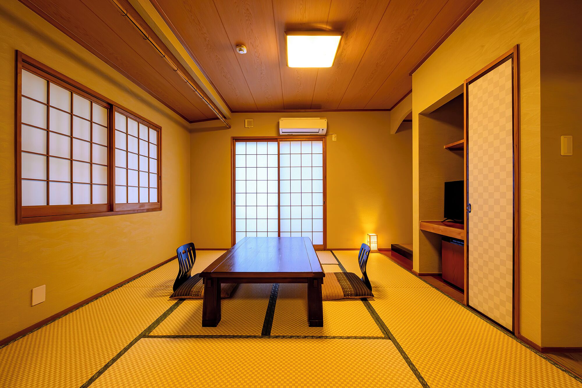 A traditional Japanese room with tatami flooring, a sliding door, and a low table.