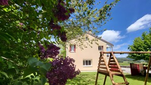 A house with a wooden swing set and a ladder in the yard. - Holiday Home “La Maison De Charlotte” in Lespéron, Ardèche (Lespéron)