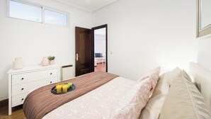 A bedroom with a bed, bedside table, and a window. - Bright and spacious apartment in downtown Madrid (Madrid)