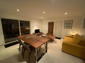 A modern living room with a wooden dining table, yellow sofa, and a TV. - ★ House 49m2 ★ Pessac ★  Netflix ★ Bus ★ Train (Pessac)