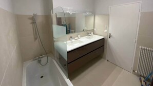 A bathroom with a bathtub, two sinks, a large mirror, and a door. - ★ House 92m2 ★ Pessac ★ Netflix ★ Bus ★ Train (Pessac)