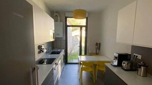 A modern kitchen with a central island, a dining table, and a view to the outdoors. - ★ House 92m2 ★ Pessac ★ Netflix ★ Bus ★ Train (Pessac)