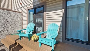 A wooden deck with two turquoise Adirondack chairs and a small potted plant. - Walk to the Beach or the Bay! (Ocean City)