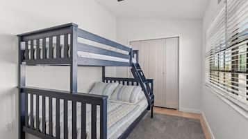 Ein Stockbett in einem Zimmer mit Fenster und Tür.