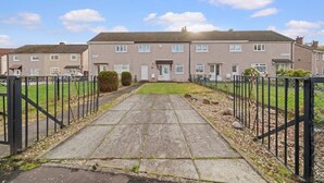 A residential building with a paved entrance, a gated driveway, and a well-maintained lawn. - Linden House - 3 bed home in Hamilton (Hamilton)