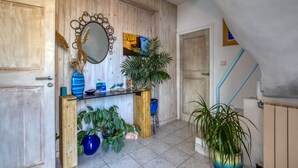 Un intérieur en bois agrémenté d’un miroir, de plantes en pot et d’un escalier.
