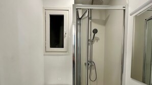 A modern bathroom with a toilet, a shower enclosure, and a sink. - C (Barcelona)