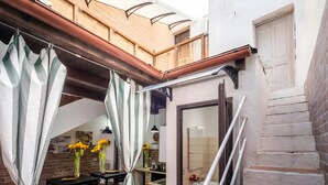 Um espaço residencial com cozinha, área de refeições e escada que leva a um andar superior.