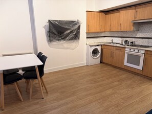 A kitchen with wooden cabinets, a washing machine, and a stove. - Maida Vale.W9.  2 bed 2 bathroom.Close Abbey Road Studios. Beautiful apartment. (London)