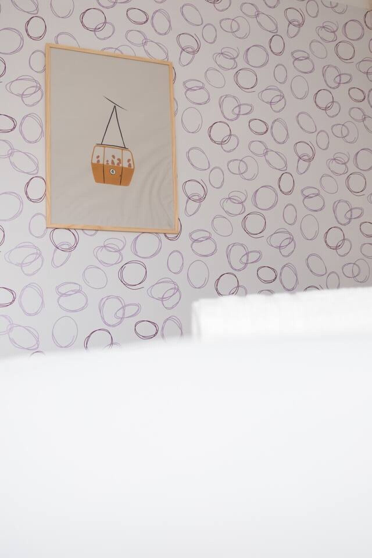 Un muro con carta da parati decorata e un quadro di un cesto appeso.