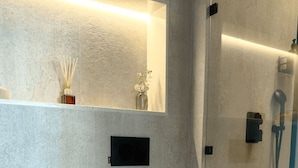 Een moderne badkamer met toilet, wastafel en douche.