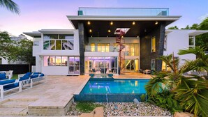 A modern two-story house with a swimming pool, outdoor seating, and a staircase leading to an upper level. - Luxury 7BR Waterfront Villa w/ Rooftop, Pool & Dock – Sleeps 14 near Las Olas (Fort Lauderdale)
