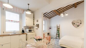 Una cocina compacta con una mesa de comedor, sillas y una cama en la habitación contigua.