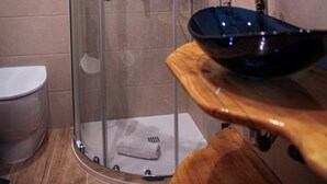 A modern bathroom with a glass shower enclosure, a wooden vanity with a sink, and a toilet. - Farfalla Bianca - Rooms (Rome)