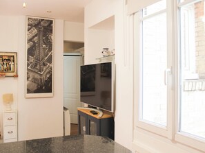 A modern kitchen with a granite countertop, a built-in oven, and a large window. - Apartment in the heart of Paris, quiet and easy (Paris)