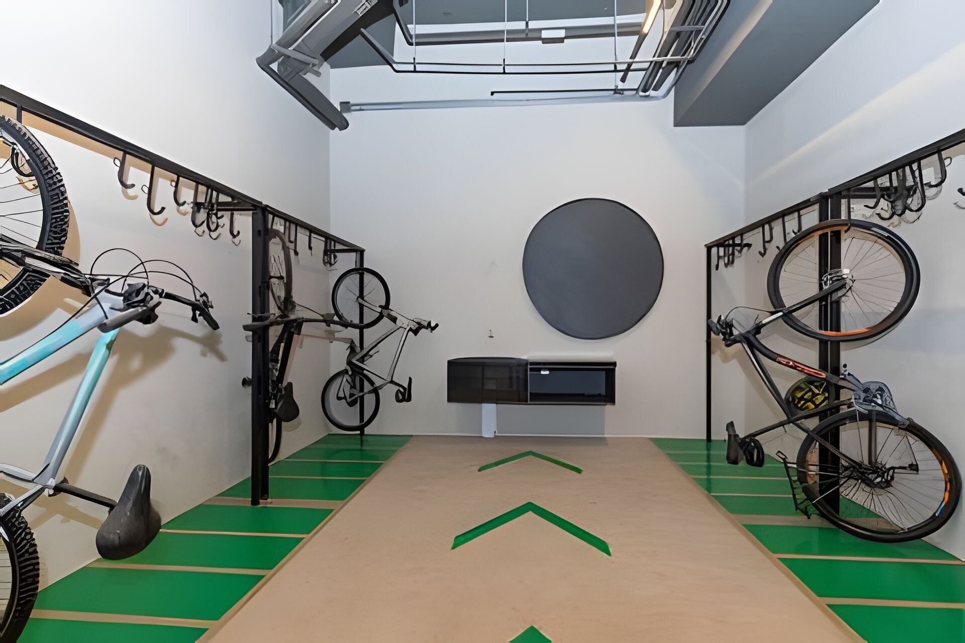 Een kamer met fietsen aan de wand bevestigd, een centrale airconditioning en pijlen op de vloer.