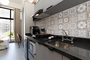 Una cocina moderna con un ventanal grande, una cafetera y un lavabo.