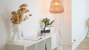 A white desk with a vase of dried flowers, a bonsai tree, and a lamp. - 3 bedroom apartment near the center of Ponte de Lima with private parking (Ponte de Lima)