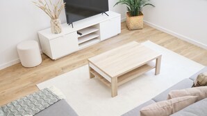 A modern living room with a grey sofa, a wooden coffee table, a white TV stand, and a potted plant. - 3 bedroom apartment near the center of Ponte de Lima with private parking (Ponte de Lima)