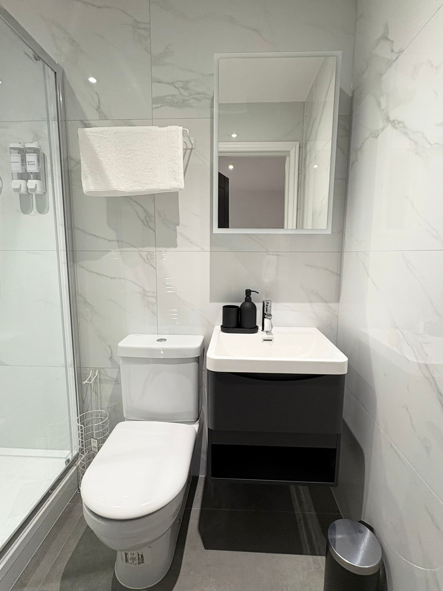 Un baño moderno con inodoro, lavamanos y ducha.
