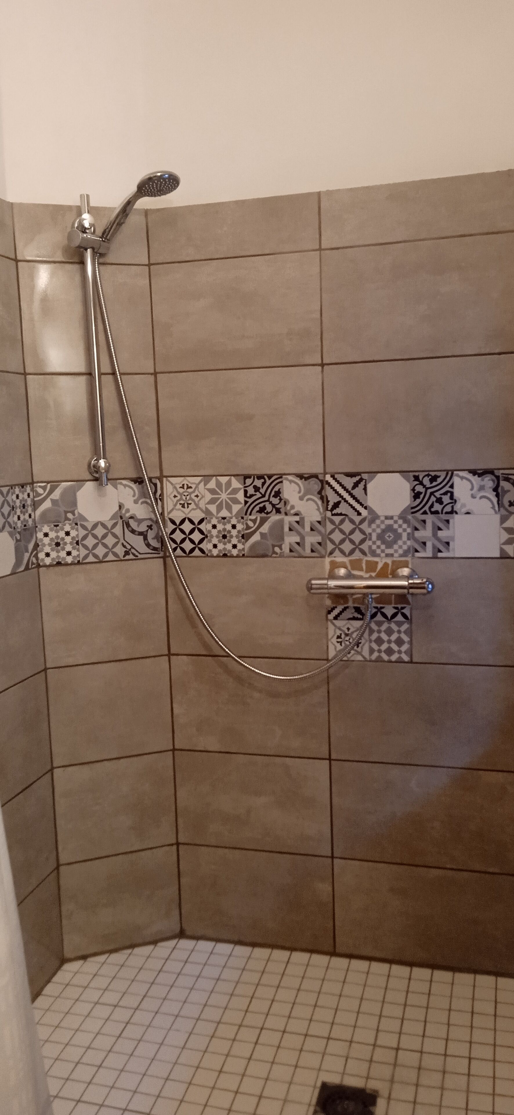 Ein Duschbereich mit Handbrause und Wandarmatur.