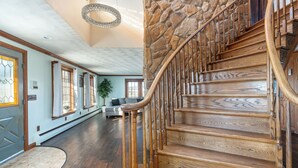 Eine imposante Treppe mit Steinwand und Holzwertung, die zu einer oberen Etage führt.