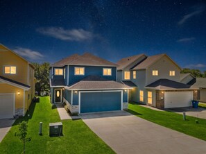 A residential neighborhood at night with houses, a well-maintained lawn, and a clear sky. - Charming Home with Lake Views & Private Pool (Lake Livingston)