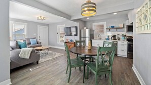 A modern apartment with a dining area, kitchen, and living room. - Charming Home in Perfect Central Spot (Galveston)