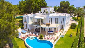 A modern two-story house with a swimming pool, outdoor seating, and a well-maintained garden. - Villa Ses Arcades II by Villa Plus (Cala d'Or)