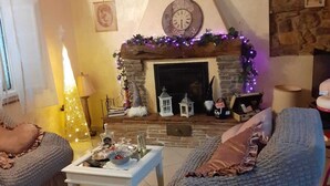 A cozy living room with a stone fireplace, a white coffee table, and two cushioned chairs. - THE HOUSE OF BAGGIORO (Capannori)