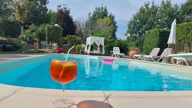 A swimming pool with lounge chairs and a white gazebo in the background. - THE HOUSE OF BAGGIORO (Capannori)