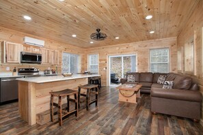Ein Holzblockhaus mit Küche, Essbereich und Wohnzimmer.